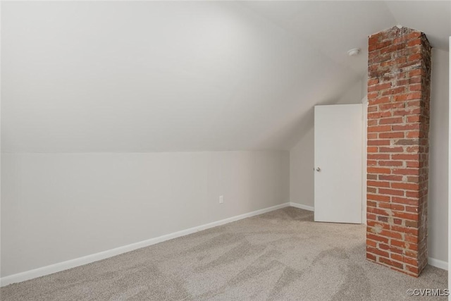 bonus room with lofted ceiling and light carpet