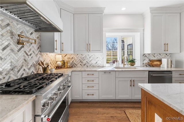 kitchen featuring appliances with stainless steel finishes, custom range hood, sink, and white cabinets