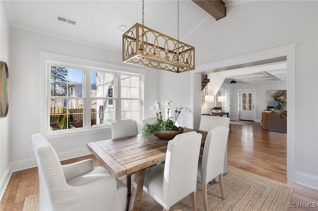 dining space featuring hardwood / wood-style flooring and lofted ceiling with beams