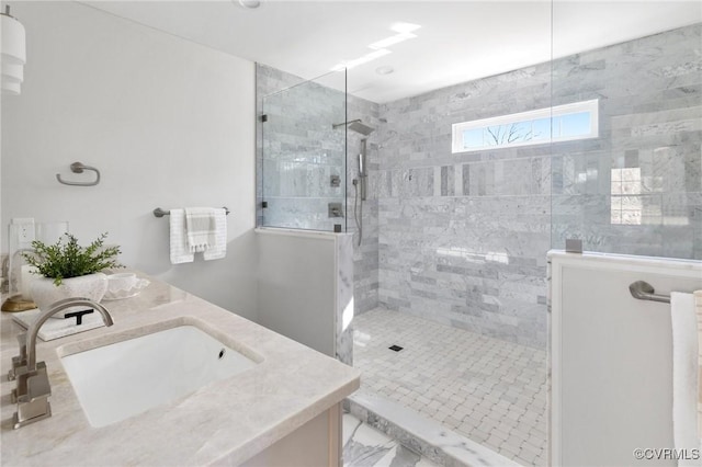 bathroom with vanity and tiled shower