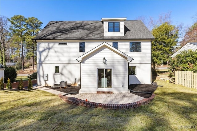 back of property with central AC, a patio area, and a lawn