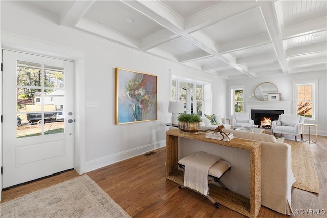 living room with coffered ceiling, wood-type flooring, beamed ceiling, and a healthy amount of sunlight