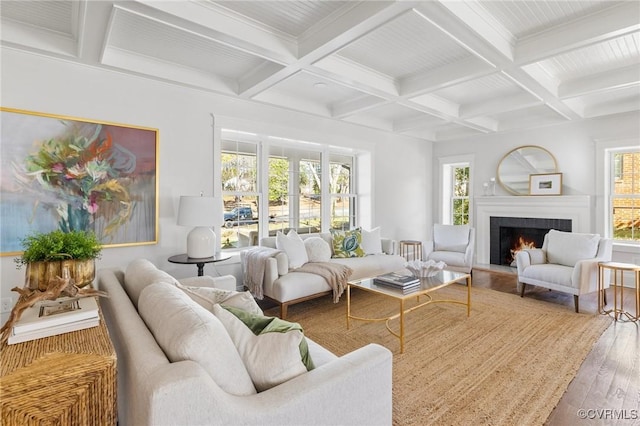 living room with hardwood / wood-style flooring, a fireplace, beamed ceiling, and a wealth of natural light