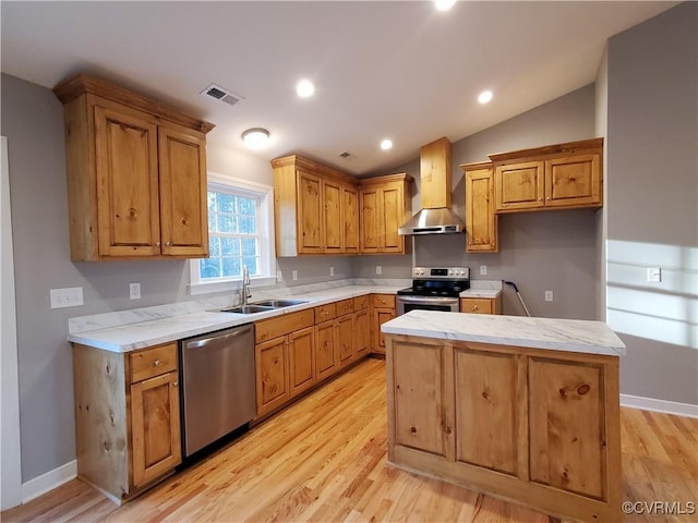 kitchen with lofted ceiling, sink, light hardwood / wood-style floors, stainless steel appliances, and wall chimney exhaust hood