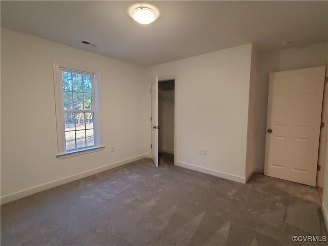 unfurnished bedroom with dark carpet