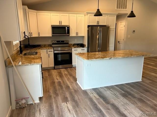 kitchen featuring pendant lighting, sink, white cabinetry, and appliances with stainless steel finishes