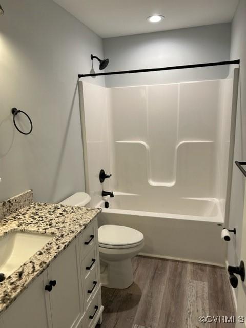 full bathroom featuring shower / bath combination, vanity, hardwood / wood-style floors, and toilet