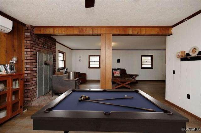 playroom with ornamental molding, a wood stove, and a textured ceiling