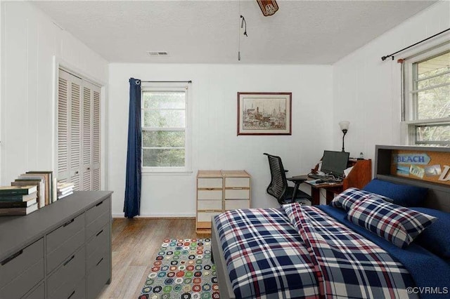 bedroom with light hardwood / wood-style flooring and a textured ceiling