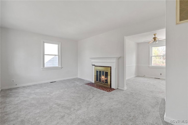 unfurnished living room with light colored carpet and ceiling fan