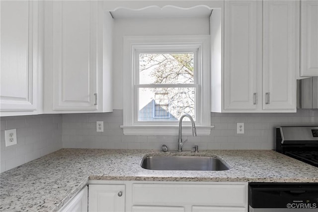 kitchen featuring tasteful backsplash, white cabinetry, sink, dishwashing machine, and light stone countertops