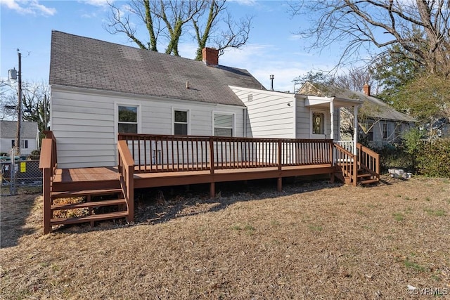 rear view of house featuring a deck and a lawn