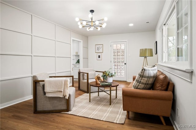 living area featuring wood-type flooring and a notable chandelier