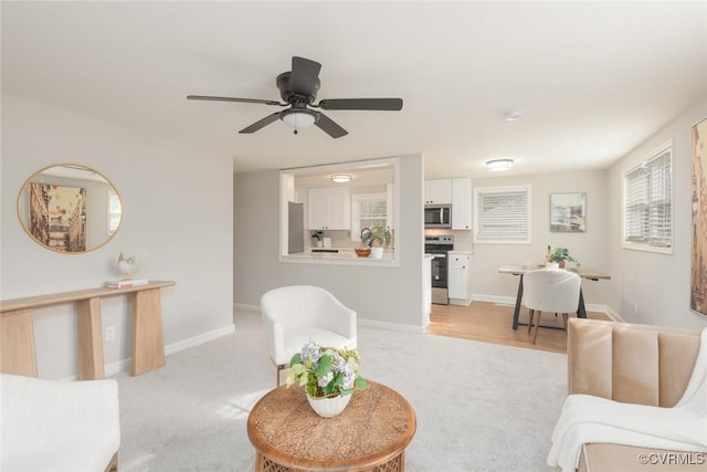 carpeted living room with ceiling fan