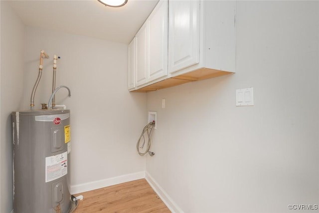 clothes washing area featuring water heater, hookup for a washing machine, light wood-type flooring, and cabinets