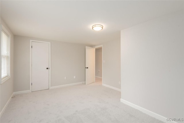 unfurnished room featuring light carpet