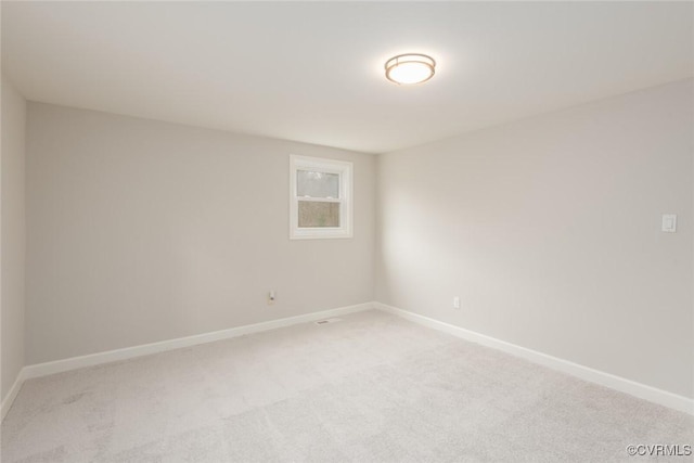 unfurnished room featuring light carpet