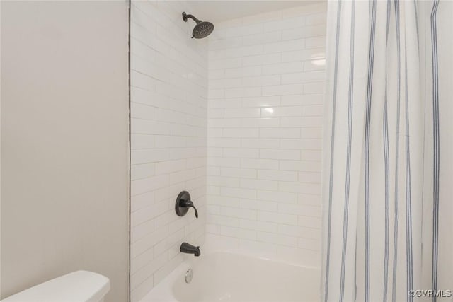 bathroom featuring tiled shower / bath and toilet