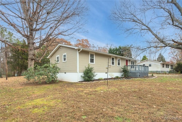 view of home's exterior with a wooden deck and a lawn