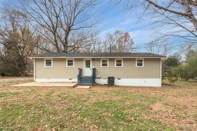 rear view of property featuring central AC unit, a yard, and a patio area