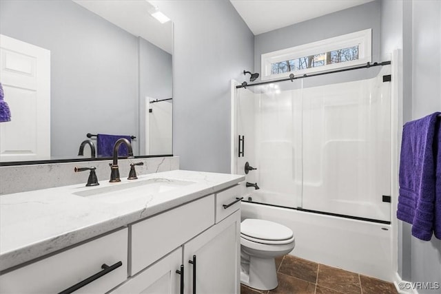 full bathroom featuring vanity, shower / bath combination with glass door, and toilet