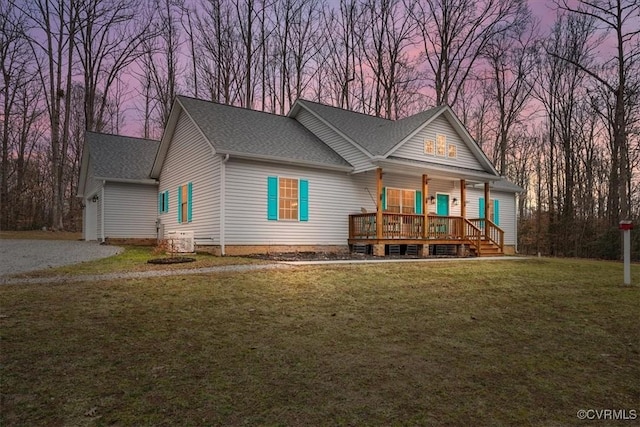 view of front of property with a garage, covered porch, and a lawn