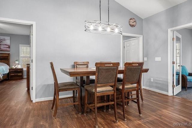 dining area featuring dark wood-type flooring and vaulted ceiling