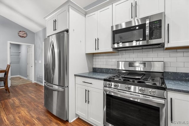 kitchen featuring lofted ceiling, white cabinetry, stainless steel appliances, dark hardwood / wood-style floors, and tasteful backsplash