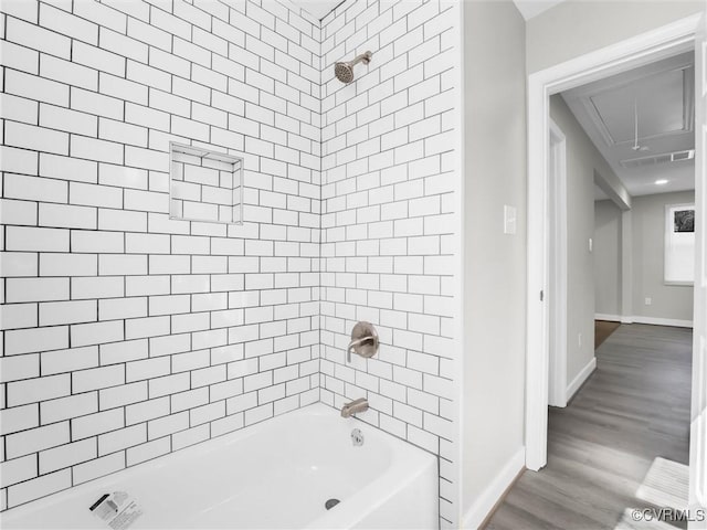 bathroom featuring tiled shower / bath and wood-type flooring