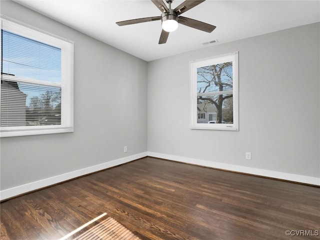 empty room with ceiling fan and dark hardwood / wood-style floors