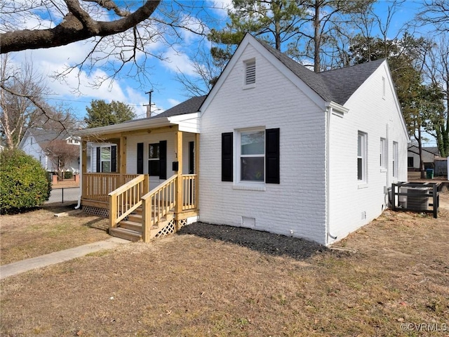 bungalow-style house featuring a porch, central AC, brick siding, a shingled roof, and crawl space