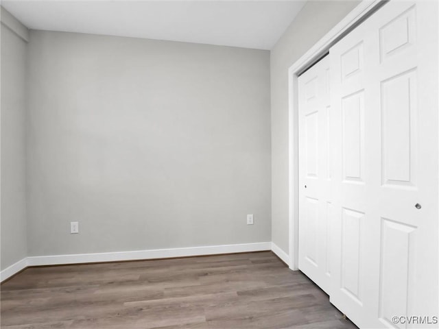 unfurnished bedroom featuring wood-type flooring and a closet