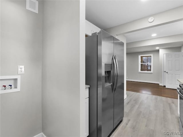 kitchen with white cabinetry, appliances with stainless steel finishes, and light wood-type flooring