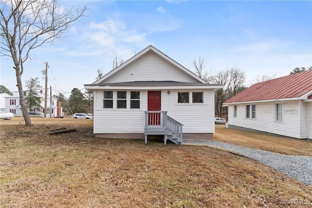 bungalow-style house featuring a front lawn