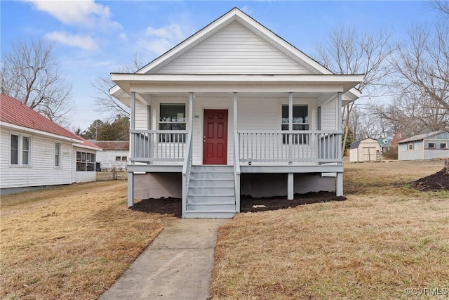 bungalow with a shed, a front lawn, and a porch