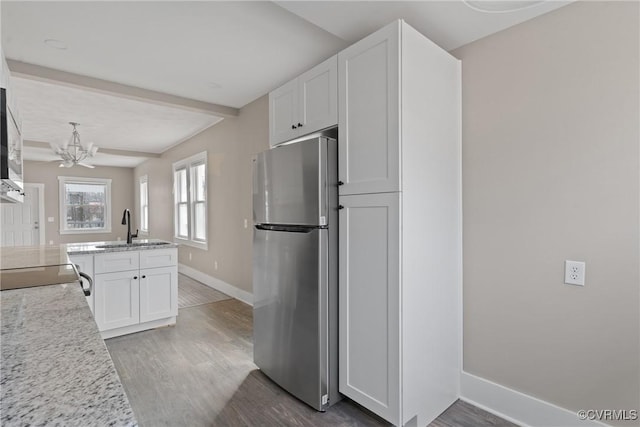 kitchen with white cabinetry, sink, stainless steel fridge, and dark hardwood / wood-style floors