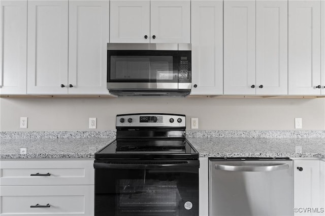 kitchen featuring appliances with stainless steel finishes, light stone countertops, and white cabinets