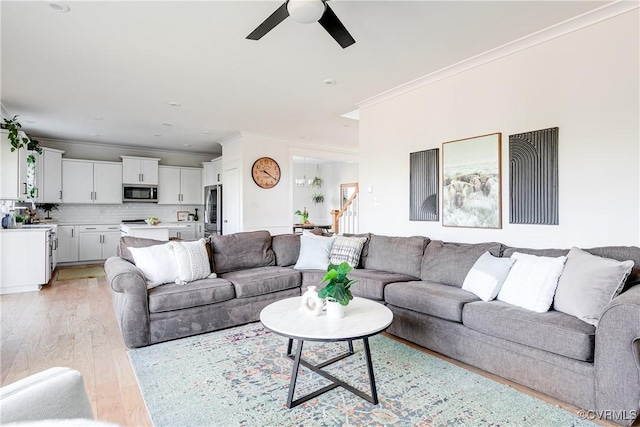 living room featuring ornamental molding, ceiling fan, and light hardwood / wood-style floors