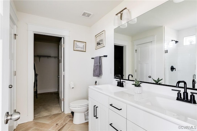 bathroom featuring vanity, toilet, and walk in shower