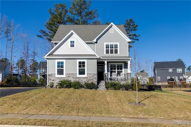 craftsman-style house featuring covered porch and a front lawn