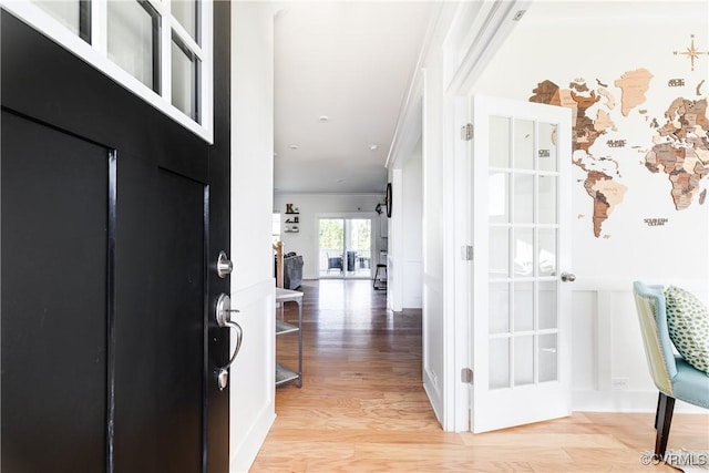 entrance foyer featuring ornamental molding and light hardwood / wood-style floors