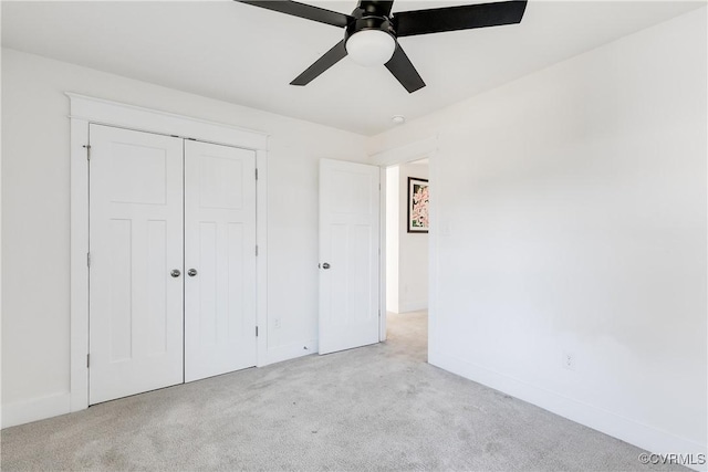 unfurnished bedroom with ceiling fan, light colored carpet, and a closet