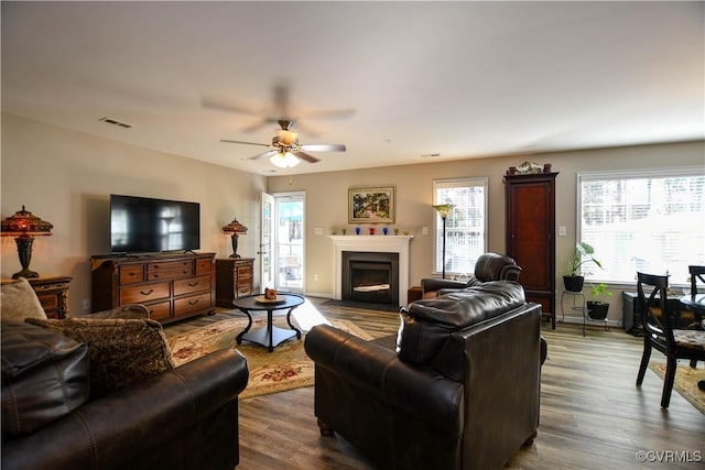 living room with dark wood-type flooring and ceiling fan