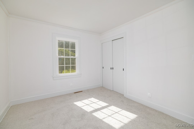 unfurnished bedroom with a closet, ornamental molding, and light carpet