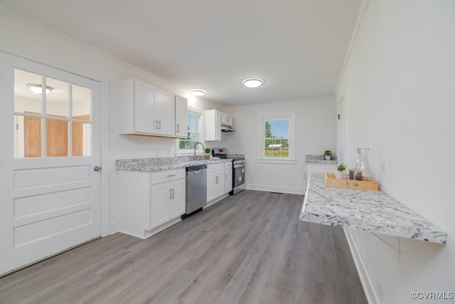 kitchen with stainless steel appliances, light stone countertops, and white cabinets