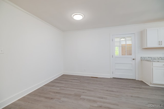 unfurnished room with crown molding and light wood-type flooring