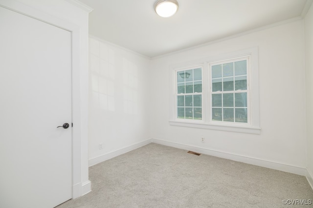 spare room with ornamental molding and light carpet