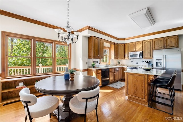 kitchen featuring light hardwood / wood-style flooring, stainless steel appliances, hanging light fixtures, and a center island