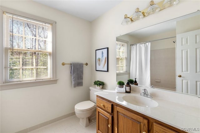 bathroom with tile patterned floors, vanity, toilet, and walk in shower