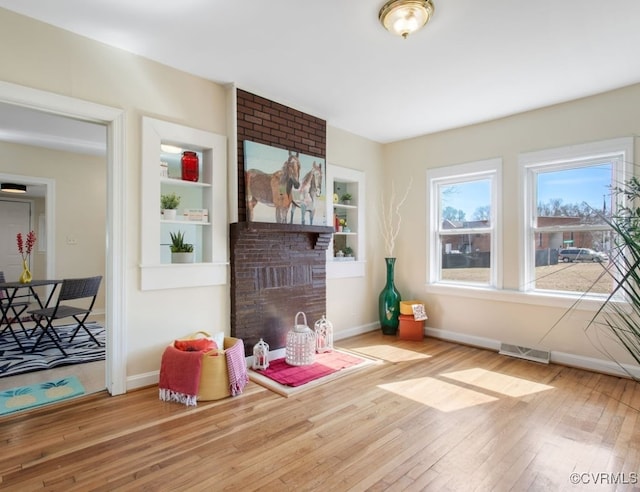 playroom featuring baseboards, hardwood / wood-style floors, visible vents, and built in features